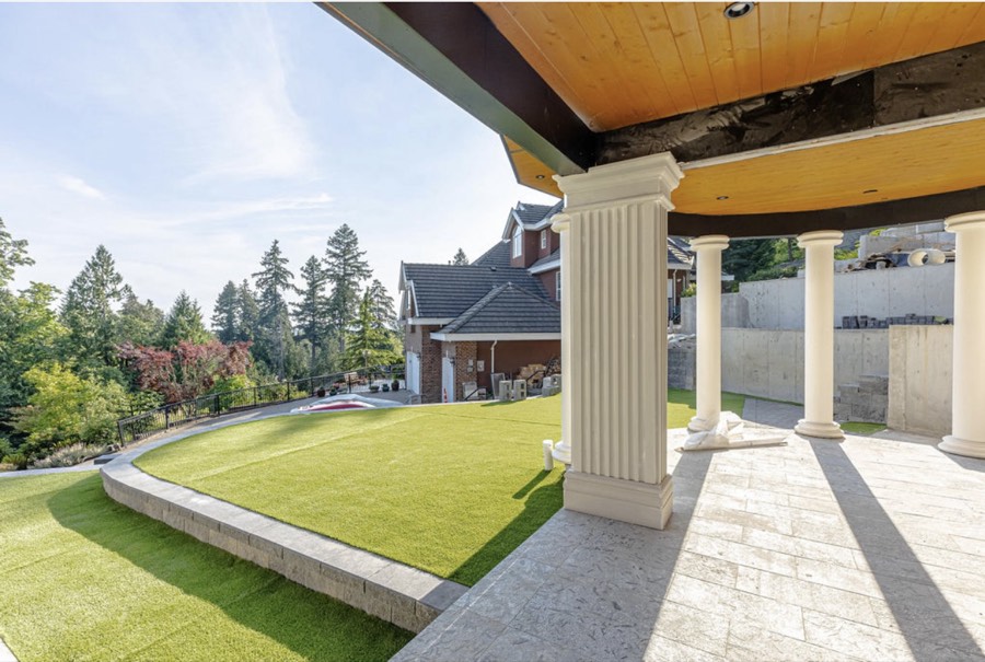 Covered patio with columns looking out over artificial turf