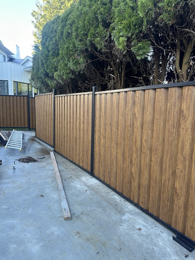 New fence panels running along a concrete pathway