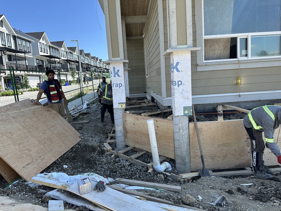 Crew working on a townhouse site with forms and rebar in place
